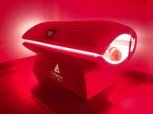 A patient laying in a closed whole-body red light therapy bed.